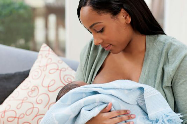 photo depicting a young woman cuddling and breastfeeding her young baby (uncredited; part of a 2013 study on breast milk from African moms and gut microbiotia published in PLoS ONE)