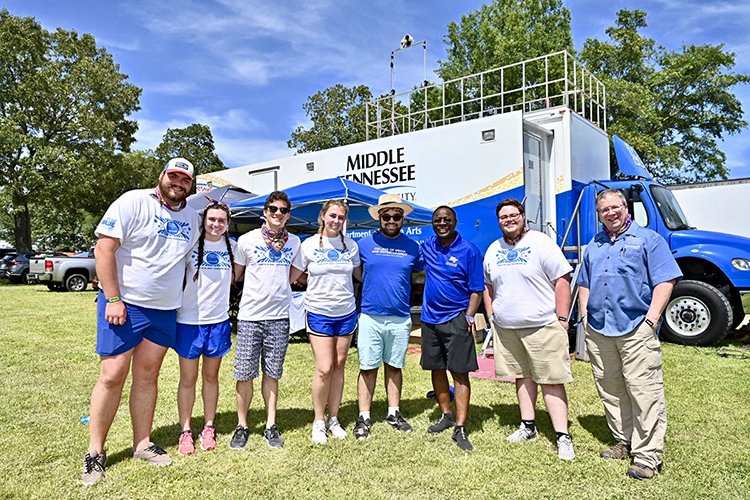 MTSU video and film production students pose with President Sidney A. McPhee, third from left, and Department of Media Arts professor Bob Gordon, right, in front of the university's $1.7 million Mobile Production Lab on Day 2 of the 2019 Bonnaroo Music and Arts Festival in Manchester, Tenn. Student multimedia teams have covered Bonnaroo each summer since 2014 as a real-world classroom and hope to do so again when the pandemic-rescheduled event opens in September. (MTSU file photo by J. Intintoli)