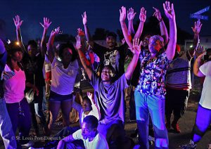 Protestors shout "hands up, don't shoot" as they confront police officers arriving to break up a crowd on Canfield Drive in Ferguson, Missouri, Aug. 9, 2014, after a police officer shot unarmed youth Michael Brown. Photo © David Carson/St. Louis Post-Dispatch