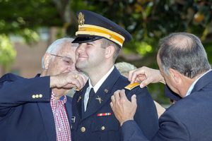 New U.S. Army 2nd Lt. Breven Addington, center, is pinned by his grandfather, Dean Trent, left, and his father, Mark Addington, both of Kingsport, during the spring 2015 military science commissioning ceremony at MTSU.