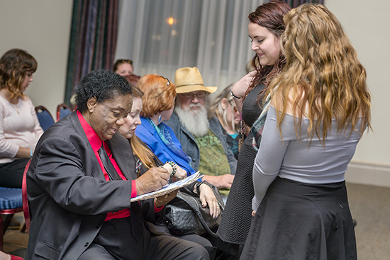 Motown music icon Lamont Dozier, left, signs the paper liner for a vinyl copy of "Motown: 25 #1 Hits from 25 Years" Wednesday, Oct. 21, for MTSU songwriting major Kayla Dunbar, center right, as her friend Heather Klein, a music business major, looks on. Seated next to Dozier is his wife, Barbara Dozier. Dozier was at MTSU for a special discussion about his 50-plus-year career and to be honored as the second Fellow of the Center for Popular Music at MTSU (MTSU photos by J. Intintoli)