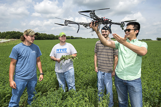 MTSU School of Agribusiness and Agriscience assistant professor Song Cui, right, shows how unmanned aircraft systems vehicles, or drones, will be used in research at the MTSU Experiential Learning and Research Center in Lascassas, Tennessee. Listening are senior Trevor Hasty, left, junior Daniel Troup and senior William West. (MTSU file photo by Andy Heidt)