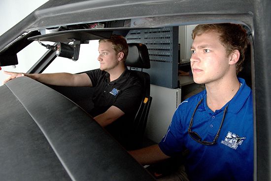 MTSU seniors Charles Greenfield, left, of Kingsport, Tennessee, and Kevin Allsop of Knoxville, Tennessee, check the view from the cockpit of the flight simulator May 5 during the dedication of the Flight Simulator Building at Murfreesboro Airport. 
