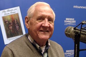 Author and MTSU alumnus J.L. Alley is shown during his interview for the June 20, 2016, episode of the radio show “MTSU On the Record,” along with the cover of his Vietnam War memoir, “The Ghosts of the Green Grass.”