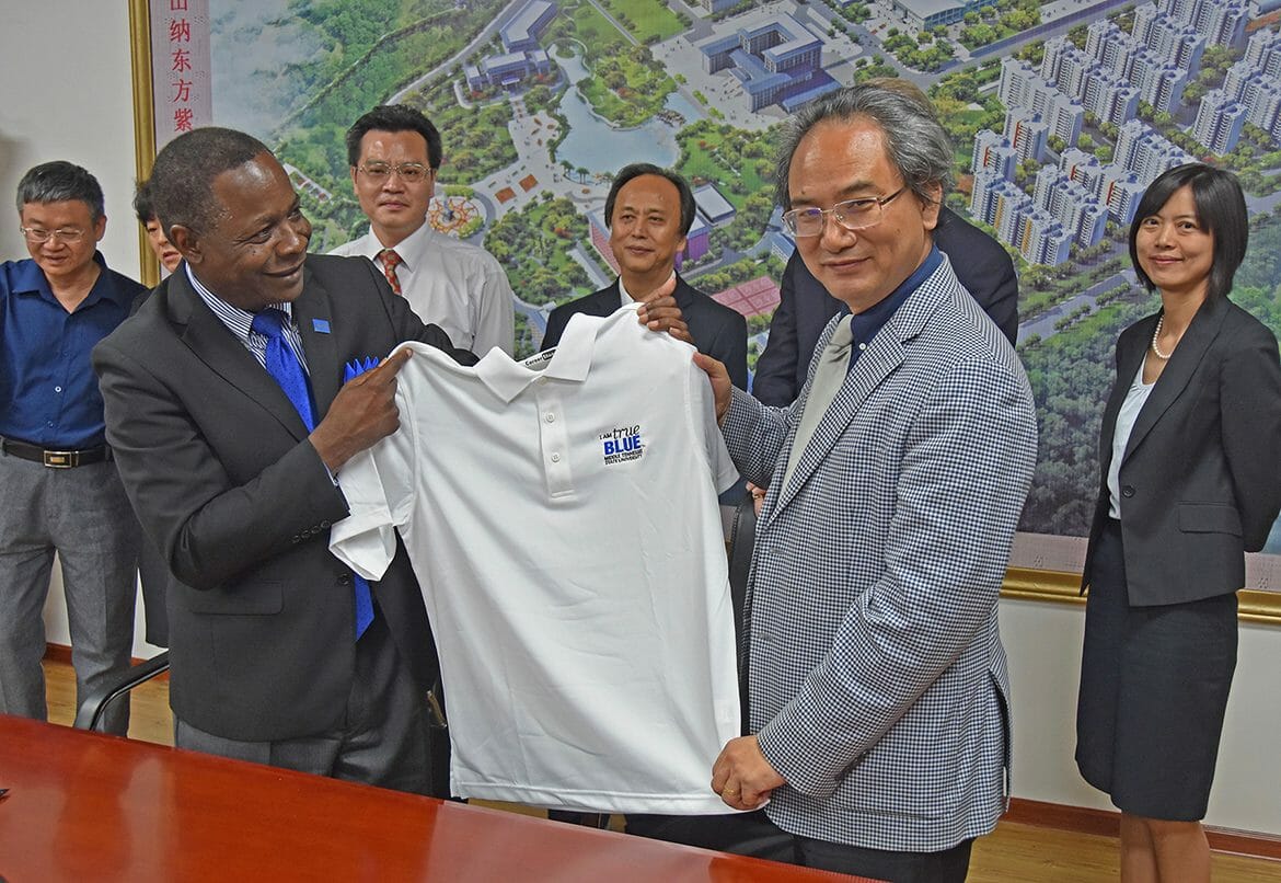 MTSU President Sidney A. McPhee presents a True Blue polo shirt to President Tang Nong of Guangxi University of Chinese Medicine on Tuesday, May 22, during McPhee’s first visit to the institution, which focuses on traditional and plant-based medicines and practices. At far right is Iris Gao, MTSU’s director of the joint International Ginseng Institute who lectured at the university. (MTSU Photo by Andrew Oppmann)