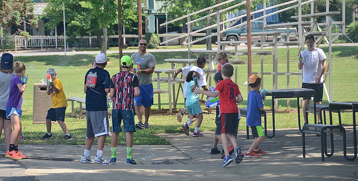 Coaches and campers cool off with a friendly water gun battle during the Wilson Collegiate Tennis Camps being hosted this summer at MTSU. (MTSU photo by Keundrea Simpson)