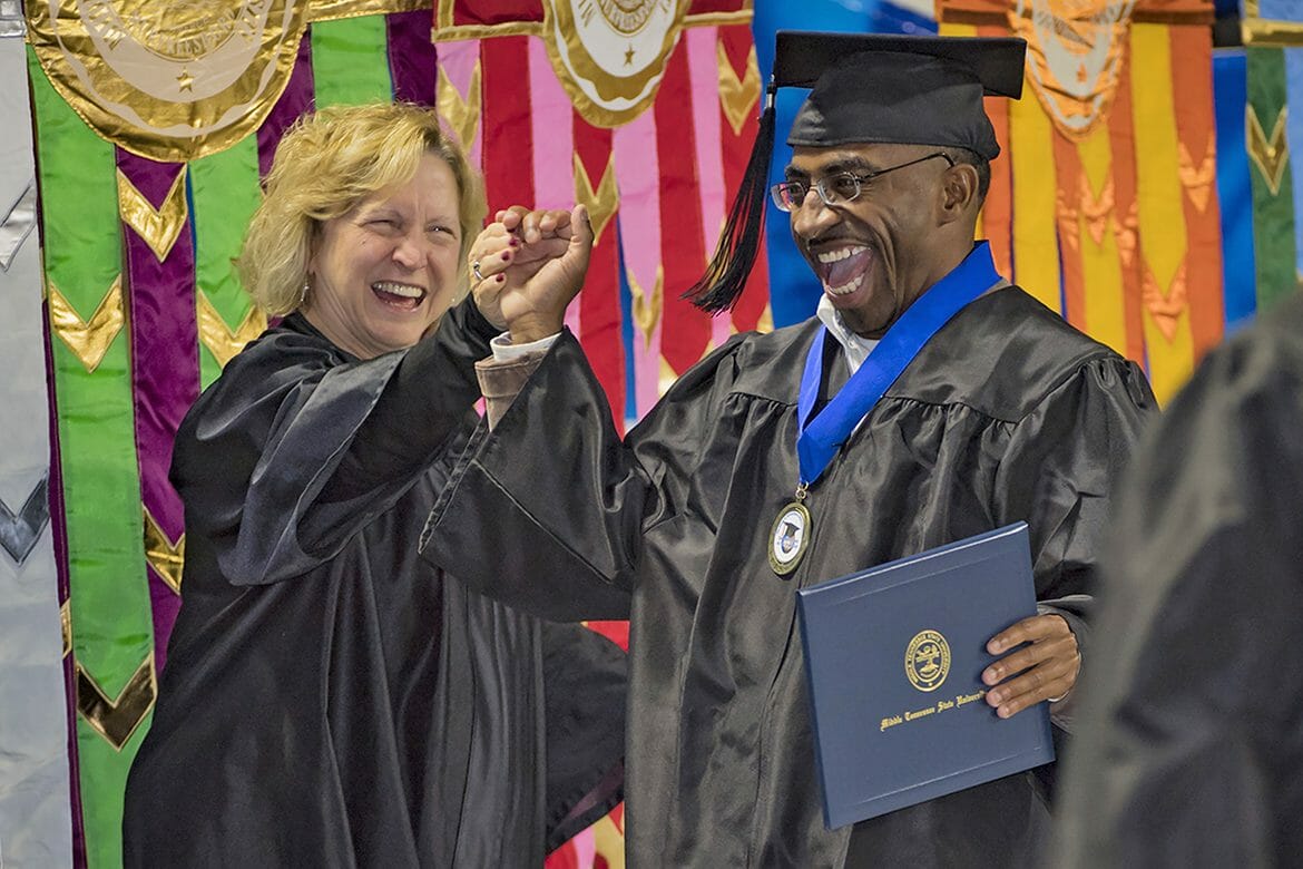 MTSU graduate Tyree Rumph receives congratulations from Pat Thomas, administrative assistant to the Board of Trustees, after receiving his degree in liberal studies during the December 2017 afternoon commencement ceremony inside Murphy Center. (MTSU file photo by Kimi Conro)