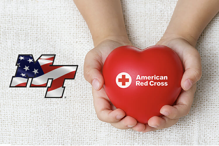 blood drive promo showing hands holding Red Cross heart alongside the MT logo with the American flag inside