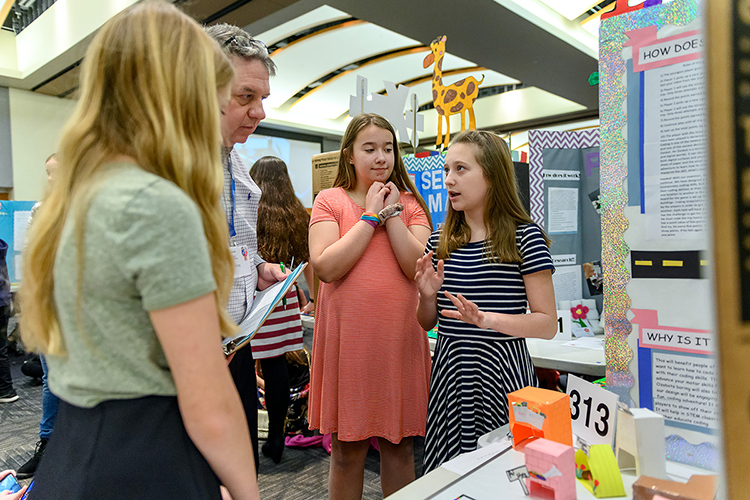 MTSU Invention Convention judge Phil King, center left, listens intently as inventor Bailey Batzloff, right, explains her team's game, "Ozobot Land," Feb. 21 in the Student Union Ballroom as her fellow inventors Reagan Turnbow, left, and Amaris McDuffie, center, wait their turn. The Murfreesboro Siegel Middle School trio's invention at the 27th annual event won first place in the Sixth Grade Games category, and the trio has been invited to the 2019 National Invention Convention in Dearborn, Mich., in May. (MTSU photo by J. Intintoli)