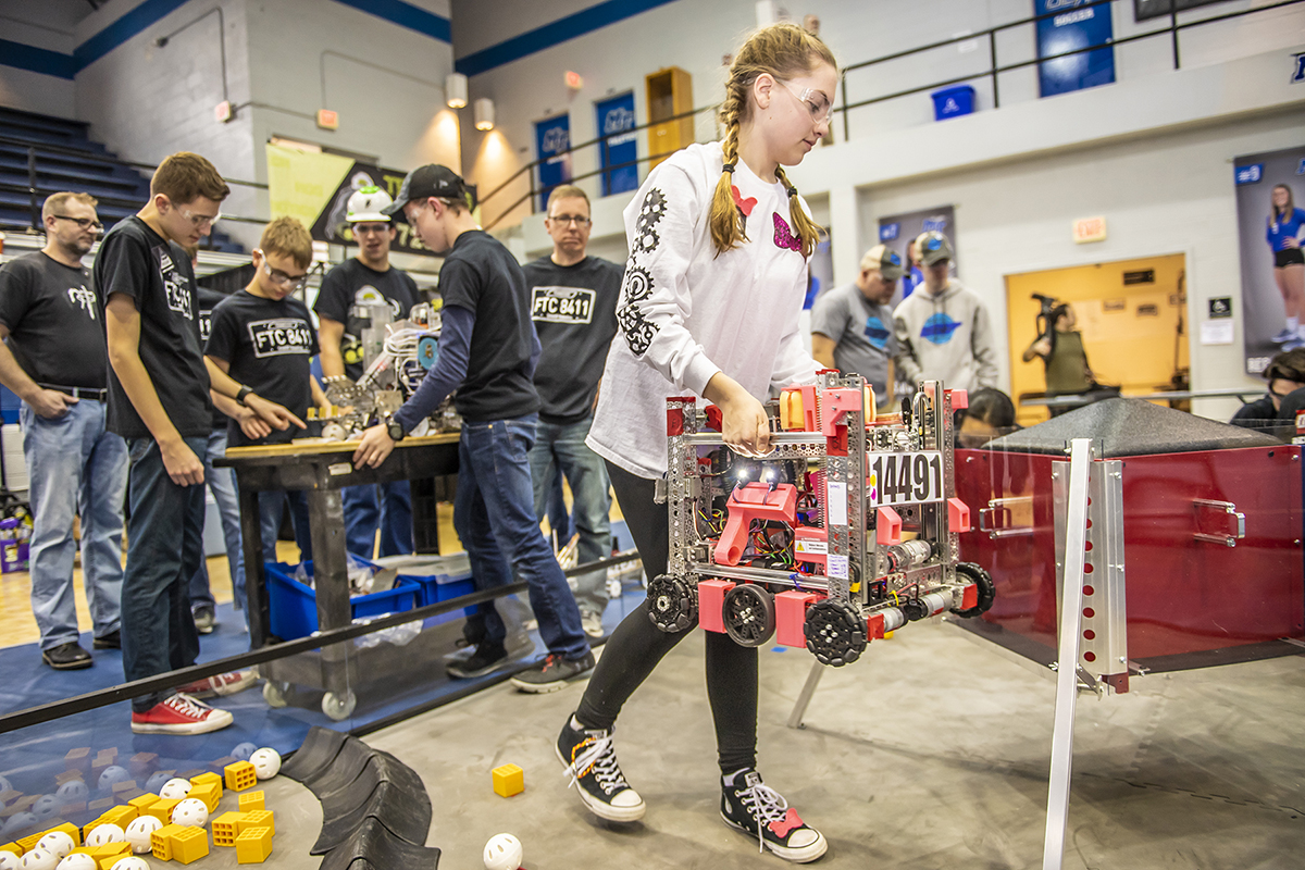 A female participant in the TNFIRST FTC Robotics Regional Competition lifts and carries the Nerdettes’ team’s entry onto the playing surface in February 2019 in Alumni Memorial Gym. The teaam was from Madison, Ala. Thirty teams will compete Saturday, Feb. 8, in AMG and Voorhies Engineering Technology competition rooms. (MTSU file photo by Eric Sutton)
