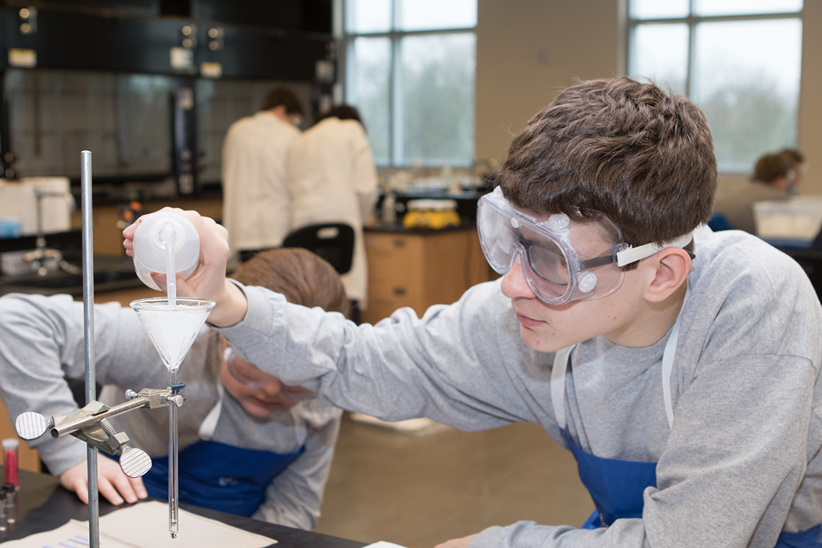 Rockvale Middle School student Jacob Wheaton pours a liquid into the funnel during the “Potions and Poisons” project he was working on Feb. 23 during the 24th annual Regional Science Olympiad at MTSU. (MTSU photo by James Cessna)