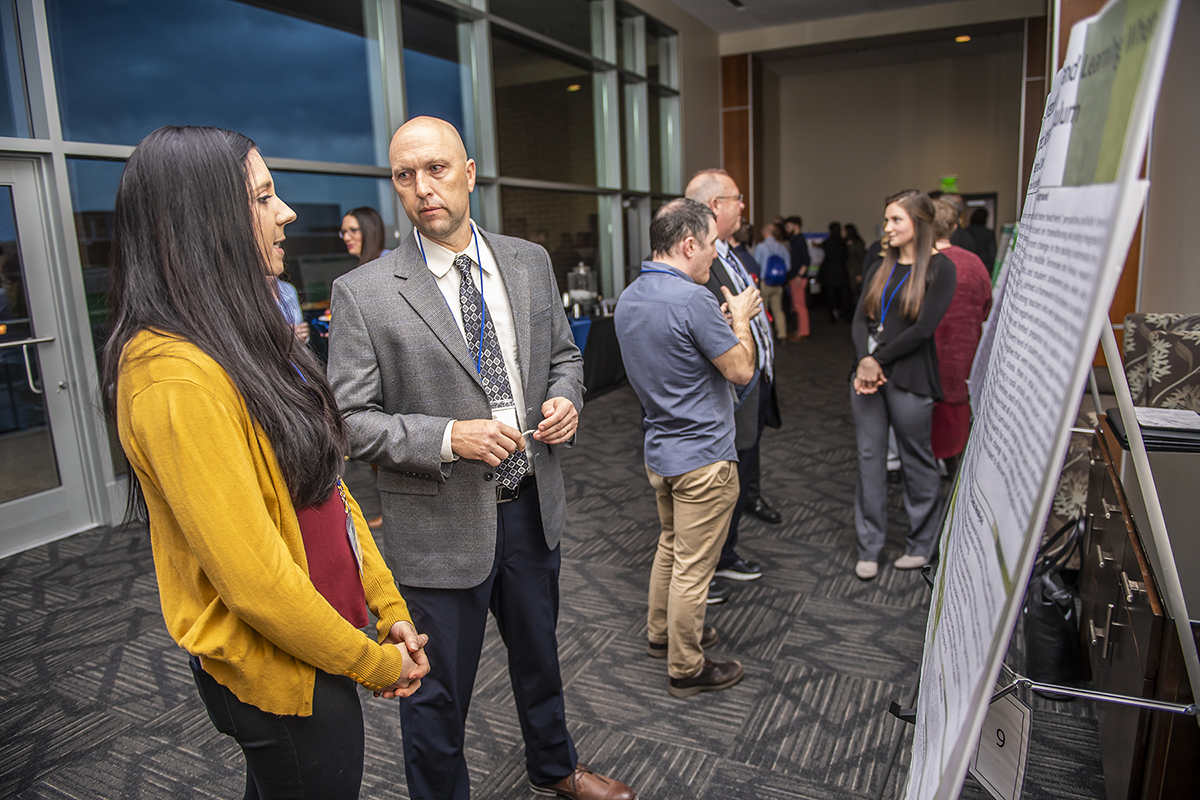 Tennessee STEM Education Center first-year Director Greg Rushton, right, learns about a research project a student conducted that was presented Feb. 14 during the center’s 13th annual STEM conference in the Student Union Building. (MTSU photo by Eric Sutton)