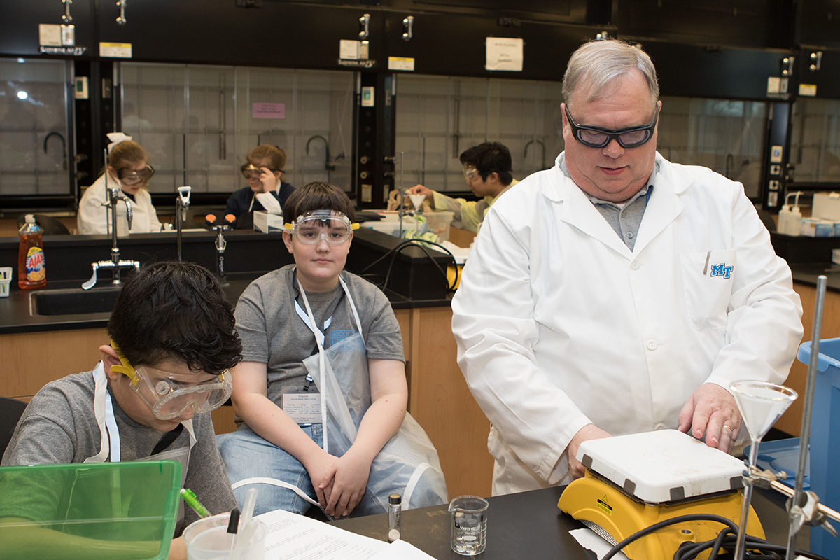 Rocky Fork Middle School participants Gavin Cardona, left, and Hayden Warner, both sixth-graders, work on their “Potions and Poisons” project as MTSU chemistry professor Paul Klinechecks the scales Feb. 23 during the 24th Regional Science Olympiad in the Science Building at MTSU. (MTSU photo by James Cessna)