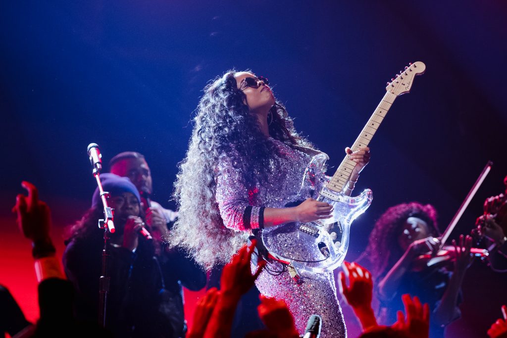 R&B Artist, HER, is playing a clear Stratocaster guitar at the 61st Annual Grammy Awards