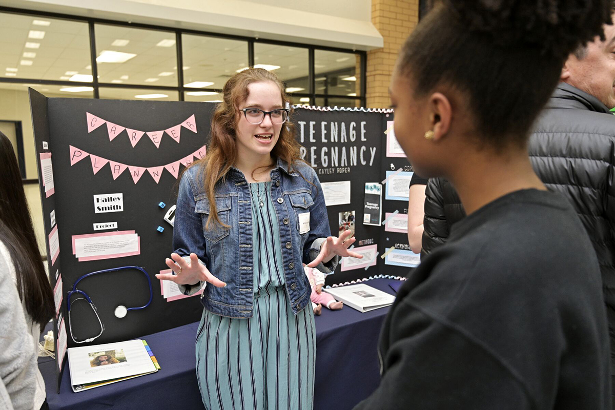 Future MTSU pre-med major Hailey Smith, left, a senior at Blackman High School, talks about her career planning capstone project she completed as part of the Blackman Collegiate Academy with Shamani Salahuddin, a Blackman junior. Partnering with MTSU, Blackman held its fourth annual Capstone Symposium March 4 in the school cafeteria. (MTSU photo by Andy Heidt)