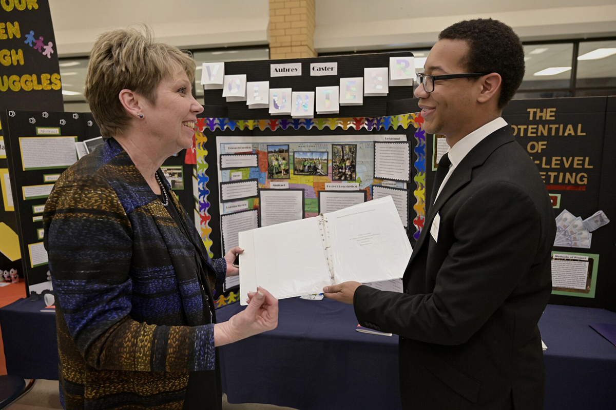 Principal Leisa Justus, left, talks to Blackman High School senior Aubrey Caster and his volunteerism capstone project as part of the Blackman Collegiate Academy March 4 in the school’s cafeteria. Caster plans to attend MTSU, which has partnered with Blackman in continuing the academy, and plans to study business and marketing in the Jones College of Business. (MTSU photo by Andy Heidt)