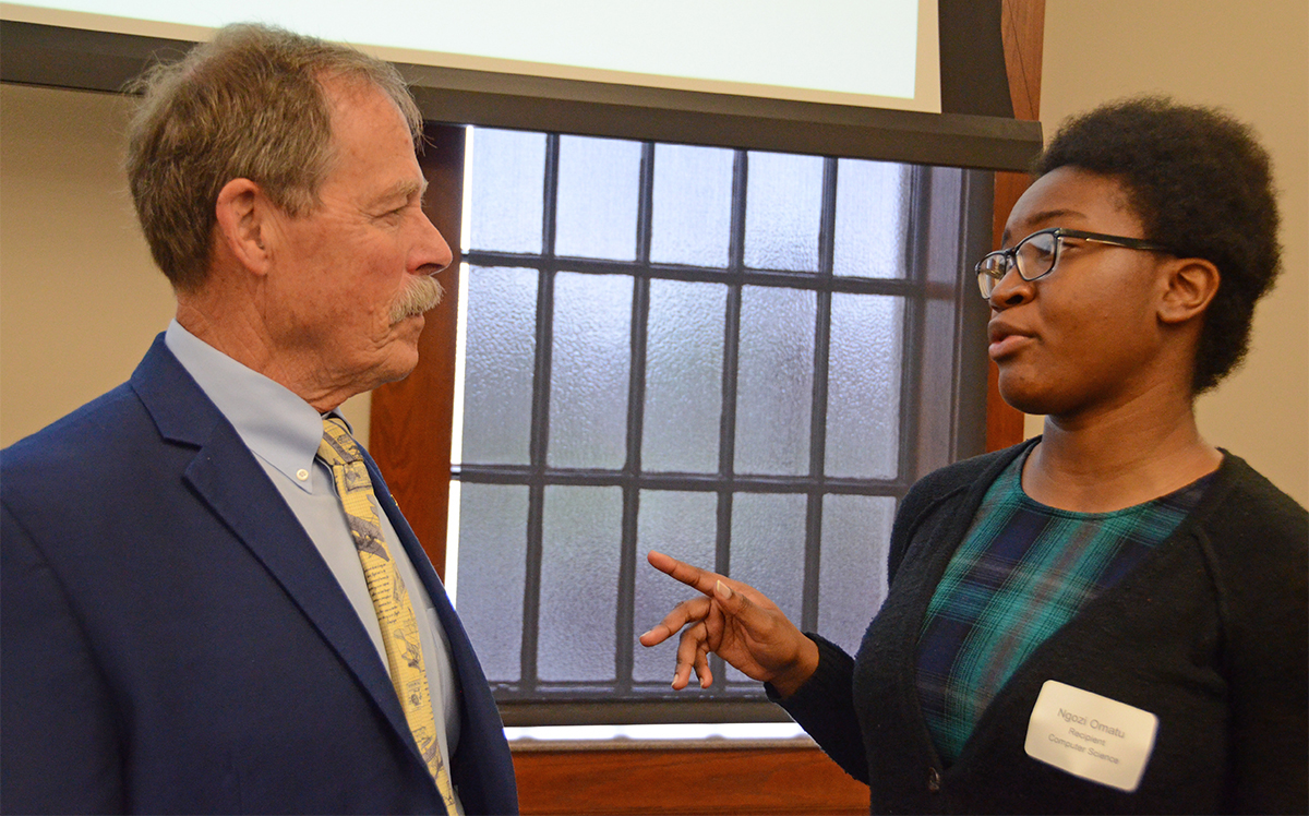 Retired NASA astronaut Robert “Hoot” Gibson, left, of Murfreesboro listens as Ngozi Omatu, an MTSU senior computer science major, shares about her research experience. They talked before a luncheon to recognize undergraduate research at MTSU. Gibson was the keynote speaker. 