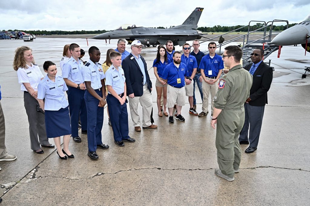 U.S. Air Force Maj. Garret Schmitz, at right in flight suit, commander of the F-16 Viper Demonstration Team, speaks with MTSU President Sidney A. McPhee, far right, and a university-led contingent visiting Smyrna Airport Friday for the last practice before the scheduled Great Tennessee Air Show this weekend. (MTSU photo by J. Intintoli)