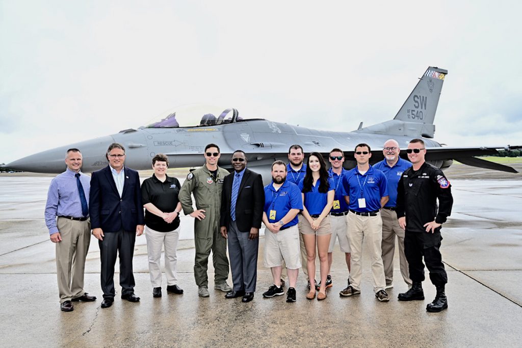 MTSU President Sidney A. McPhee, fifth from left, poses for a photo Friday at Smyrna Airport with other university faculty, staff and students as well as members of the F-16 Viper Demonstration Team, which hosted the group for the last practice before the scheduled Great Tennessee Air Show this weekend. To the left of McPhee is U.S. Air Force Maj. Garret Schmitz, commander of the Viper demo team. (MTSU photo by J. Intintoli)