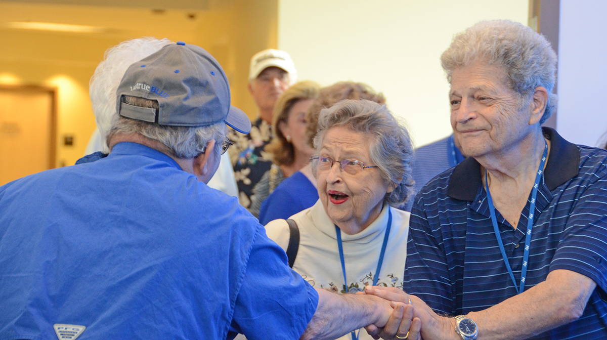 Alumni Summer College attendees Helen (Classes of 1968, ’69, ’70 and ’72), center, and Glen (’69, ’86) Emery greet fellow MTSU alumnus Joe Nunley Jr. (’69, ’74) in a blue carpet setting in the Miller Education Center. Nearly 80 alumni attended the three-day event this year. (MTSU photo by Randy Weiler)