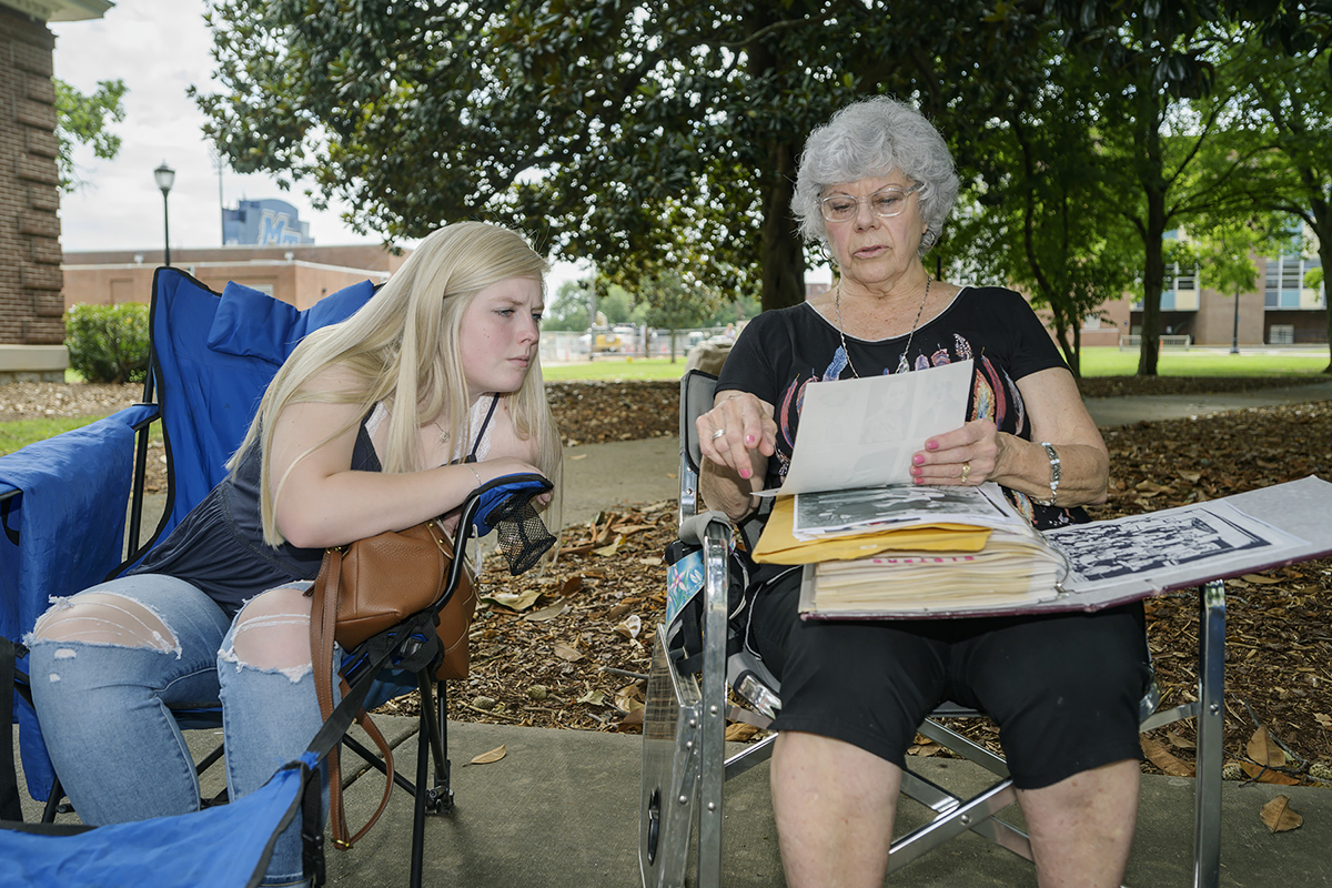 At the MTSU Veterans Memorial site, Kara Brady, a college student from Bradenburg, Ky., views copies of photographs that her grandmother, Dianne Hager, has of Hager’s brother, U.S. Army Capt. Jimmy Schleicher, who died June 26, 1944. Hager was born 10 days after he perished. Both attended MTSU. (MTSU photo by Andy Heidt)
