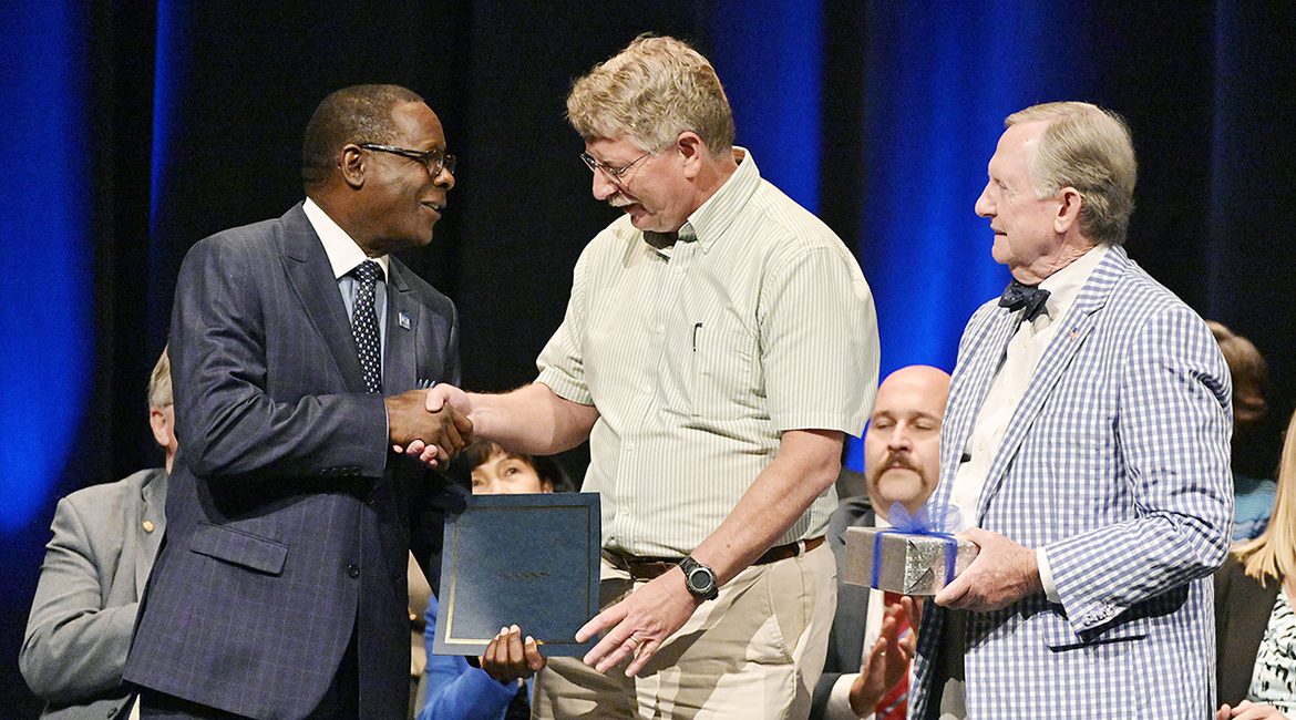MTSU President Sidney A. McPhee, right, congratulates physics professor William Robertson, center, on winning the MTSU Foundation’s 2019 Career Achievement Award as Foundation President Ron Nichols watches on the stage of Tucker Theatre Thursday, Aug. 22, at the university’s Fall Faculty Meeting. During the gathering, the MTSU Foundation honored 15 professors with awards for their service and recognized new faculty emeriti and newly promoted and/or tenured professors, and McPhee presented his annual State of the University address. MTSU begins its 108th academic year Monday, Aug. 26, when fall 2019 classes begin. Details on Robertson’s and his colleagues’ accomplishments are available at http://bit.ly/MTSUFacultyAwards2019. (MTSU photo by Andy Heidt)
