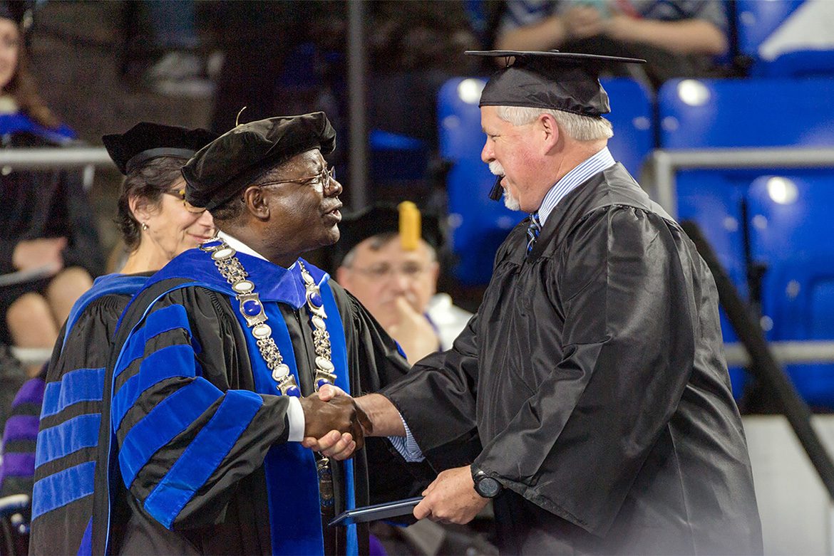 MTSU President Sidney A. McPhee congratulates a graduate at MTSU’s Summer 2019 Commencement ceremony in Murphy Center. (MTSU file photo by Grad Images)