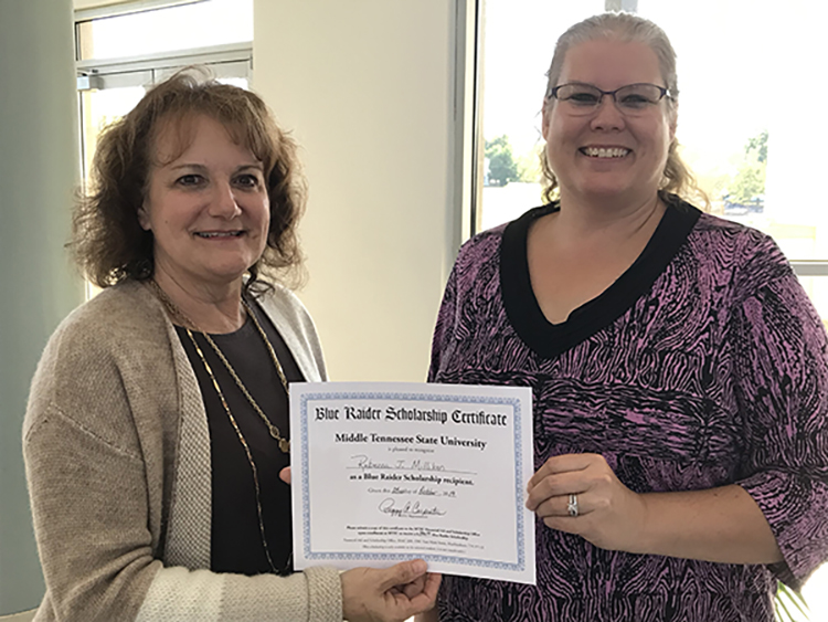 Peggy Carpenter, assistant dean of University College, presents Becky Milliken with a scholarship certificate at the Finish Your Degree Q&A event held Oct. 23 at the Rutherford County Chamber of Commerce in Murfreesboro, Tenn. (MTSU photo by Hunter Patterson)