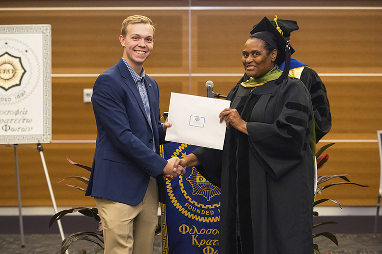 Mark Blackmon, left, receives his certificate of induction into The Honor Society of Phi Kappa Phi from Dr. Barbara Turnage, interim associate dean of the College of Behavioral and Health Sciences, at the fall 2019 PKP induction ceremony Nov. 12 in the Student Union Building. (MTSU photo by Cat Curtis Murphy)
