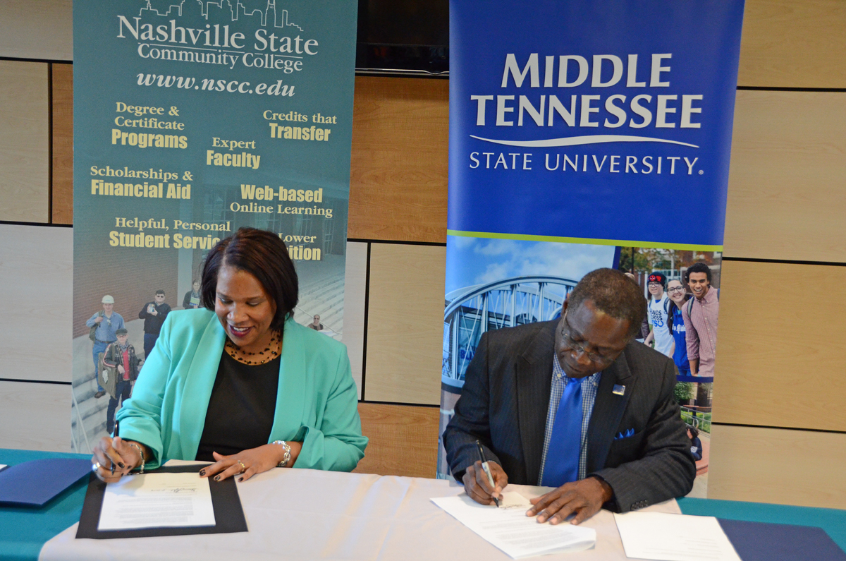 Presidents Shanna L. Jackson, left, of Nashville State Community College and Sidney A. McPhee of Middle Tennessee State University sign an agreement marking the “True Blue Pathway” to Nashville State, the eighth such agreement established for students with associate degrees to move seamlessly to the four-year university. The signing occurred Nov. 20 at Nashville State’s main campus on White Bridge Road in Nashville. (MTSU photo by Randy Weiler)