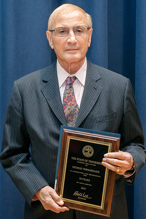 MTSU professor George Vernardakis of Murfreesboro, a member of the Department of Political Science and International Relations, poses with a plaque recognizing his 50 years of service to the university. Vernardakis, who also coordinates the political science department’s graduate programs, was among more than 230 faculty and staff members at MTSU recognized for their years of service at the university’s annual Service Award Luncheon, held Dec. 5 in the James Union Building. (MTSU photo by James Cessna)