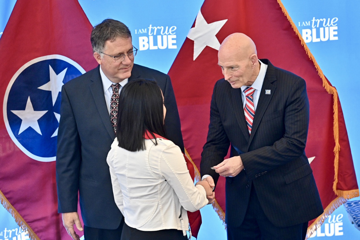 MTSU ROTC cadet Neily Jiminez, center, received a Challenge Coin, which is a tradition in military history, from retired U.S. Army Lt. Gen. Keith M. Huber, right, and MTSU Provost Mark Byrnes watches Wednesday, Dec. 4, during the 15th Graduating Veterans Stole Ceremony at the Miller Education Center on Bell Street. Student veterans received their red stoles that can be worn Saturday, Dec. 14, during MTSU commencement ceremonies. Huber is senior adviser for veterans and leadership initiatives at MTSU. (MTSU photo by J. Intintoli)