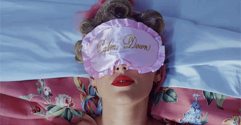 Taylor Swift wearing sleeping mask that says "you need to calm down"