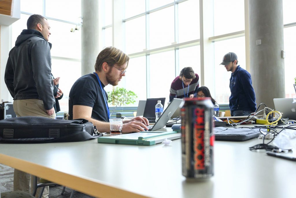 One of the teams in the fifth annual HackMT at MTSU collaborates to apply the finishing touches to its project just before the judged science fair portion of the event in January 2020 in the Science Building’s second-floor atrium. College students gather in person Jan. 28-30 to form teams in the seventh annual hack-a-thon competition. (MTSU file photo by Cat Curtis Murphy)