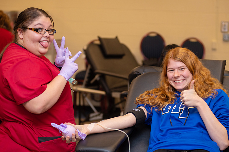 Avery Garfield, right, a sophomore nursing major, cuts up with an American Red Cross blood services technician while donating blood Feb. 10 in MTSU's Keathley University Center during the university's 2020 valentine blood drive. (MTSU photo by James Cessna)