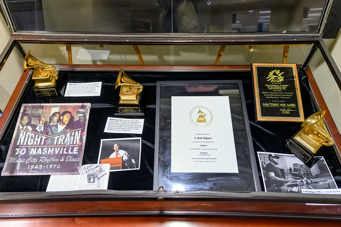 Some of the Grammy recognition for MTSU alumni is shown inside a display case in “A Legacy of Excellence: MTSU at the Grammys,” an exhibit at the university's James E. Walker Library on view through the end of February. The items include, clockwise from top left, a Grammy won by MTSU recording industry lecturer and Master of Arts in Liberal Arts alumnus Roy E. "Bubba" Smith, producer of the 2000 best traditional soul album, "You Can Make It" by Shirley Caesar; the Grammy that alumnus Michael Gray (B.S. '92, M.S. '97) received as co-producer of the 2005 best historical album, "Night Train to Nashville: Music City Rhythm & Blues, 1945–1970"; a certificate of recognition for 1994 alumnus F. Reid Shippen, who engineered the 2012 best country duo/group performance Grammy winner, "Pontoon," by Little Big Town; a plaque from the Recording Academy, then the National Academy of Recording Arts and Sciences, recognizing MTSU in the inaugural NARAS Student Music Awards for outstanding achievement in the jazz/big band category; Shippen's Grammy for engineering the 2007 best pop/contemporary gospel album, "Wherever You Are" by Third Day, and a photo of him in the studio; and a photo of Gray alongside a copy of the "Night Train to Nashville" album and its liner notes autographed by music legend Etta James. (MTSU photo by J. Intintoli)