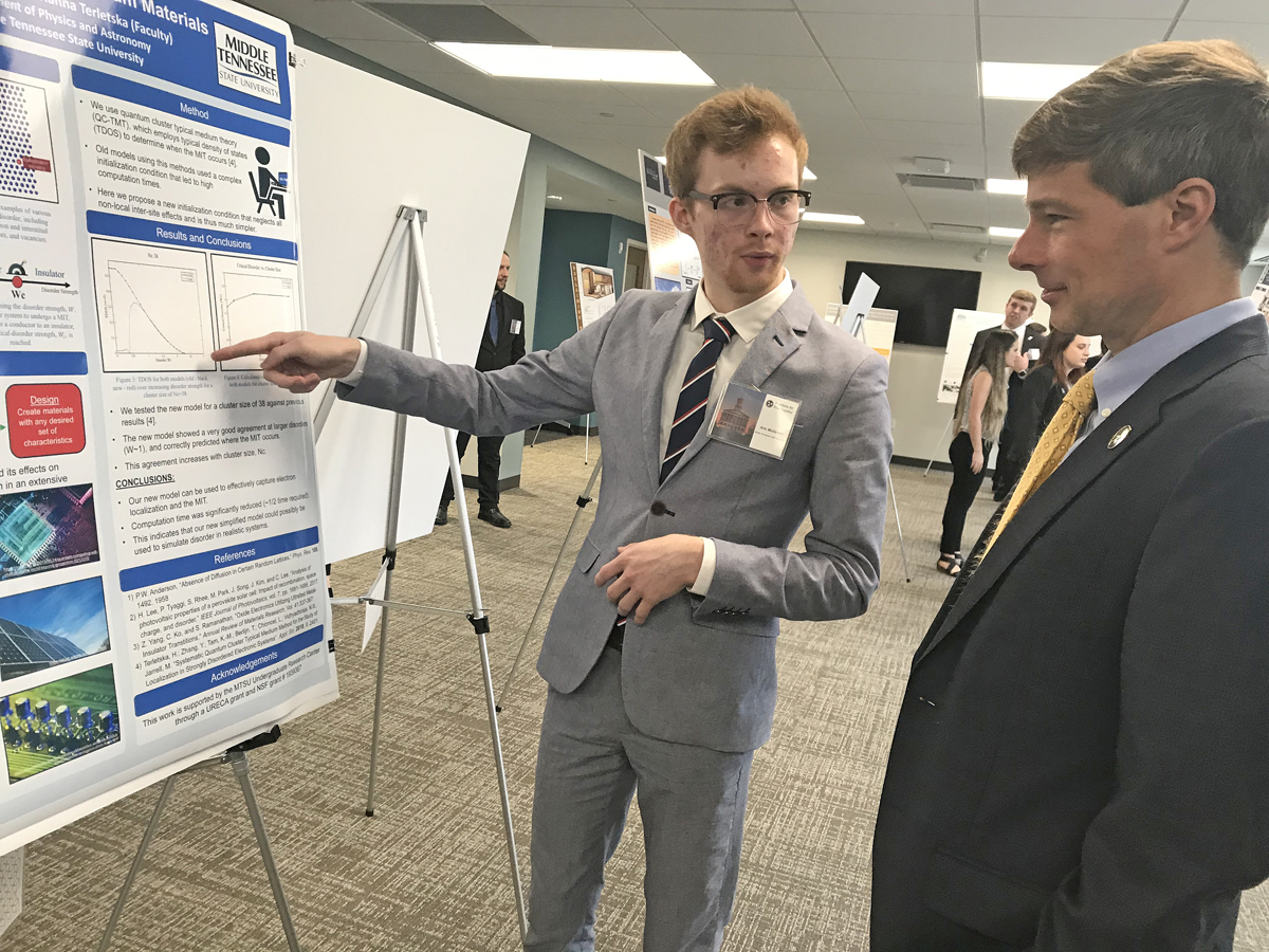 MTSU senior Aric Moilanem, left, a physics major from Crossville, Tenn., offers an explanation of his quantum materials research to state Rep. Charlie Baum, an MTSU finance professor, Wednesday, Feb. 26, during the annual Posters at the Capitol in Nashville, Tenn. MTSU joined eight other universities and nearly 60 students at the event. (MTSU photo by Randy Weiler)