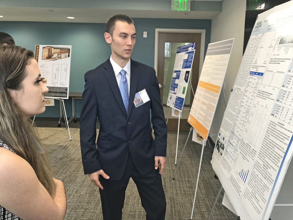 Recent Goldwater Scholarship honoree Jared Frazier, right, a rising MTSU junior chemistry and computer science major, explains his research regarding explosives to University of Memphis senior Serena Jones in late February during the annual Posters at the Capitol research event in Nashville, Tenn. Frazier was among 60 students sharing their research with state legislators and others. (MTSU file photo by Randy Weiler)