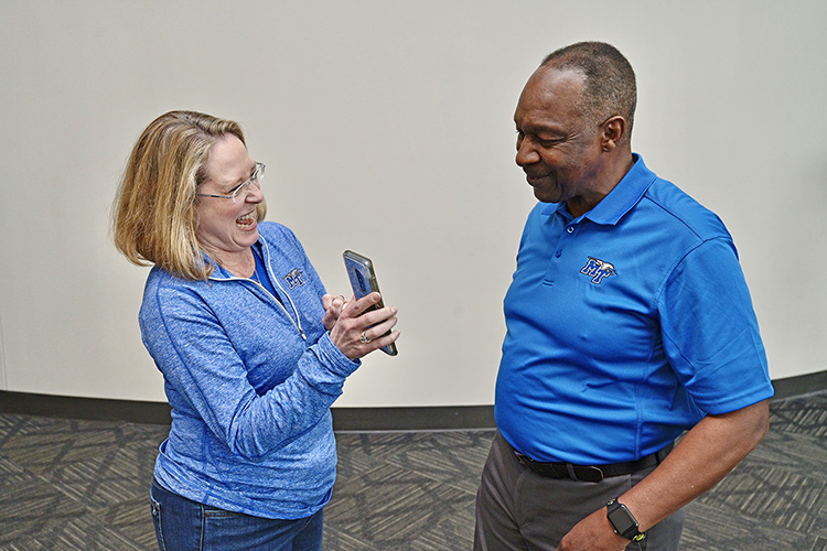 Erin Hayes, daughter of legendary MTSU track coach Dean Hayes, shares a photo with former hurdler Lonnell Poole, who returned to campus Thursday, Feb. 6, along with seven other of the university’s first black student-athletes for a panel discussion for the True Blue Pioneers event in the Student Union Ballroom. (MTSU photo by Andy Heidt)