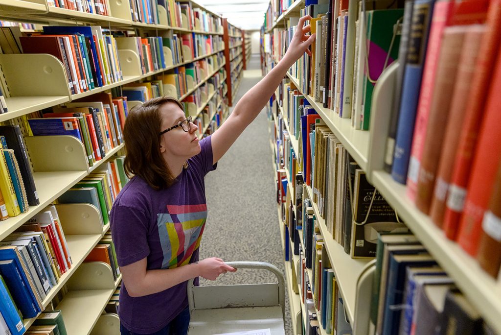 Molly Burnette, a user service assistant in the James E. Walker Library, pulls books off the shelves as part of the “Pull and Hold” service provided by the library during the COVID-19 outbreak. (MTSU photo by J. Intintoli)