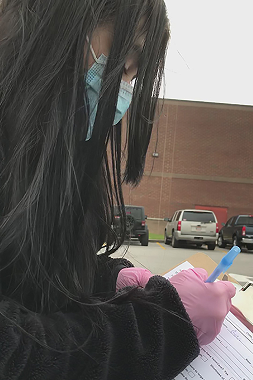 With a mask covering her nose and mouth and gloves on her hands, this young woman documented information about MTSU employee Gina Logue in preparation for Logue’s COVID-19 test April 18 in Shelbyville, Tenn. (Photo submitted)