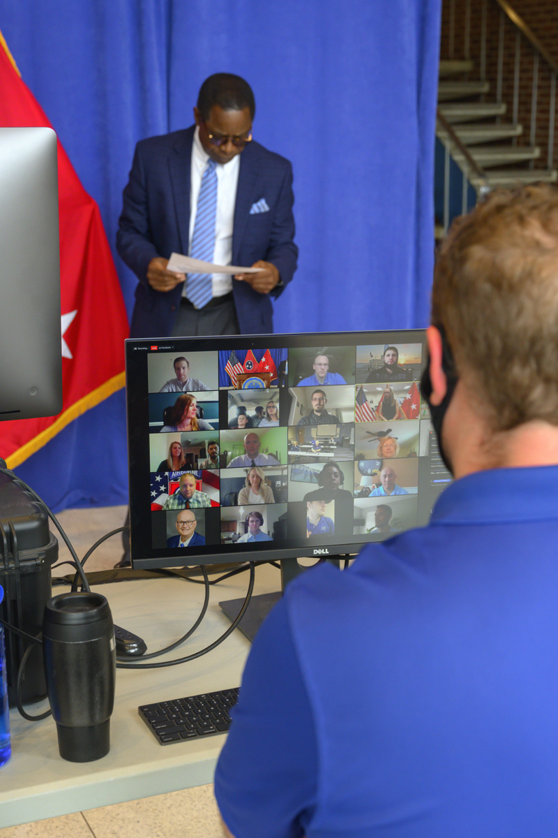 As MTSU President Sidney A. McPhee reviews his notes before speaking, MTSU Marketing and Communications strategic communications manager John Goodwin views a group of Zoom participants on the computer screen during the virtual Graduating Veterans Stole Ceremony Wednesday, April 29, in the Cope Administration Building lobby. It is an event for the Charlie and Hazel Daniels Veterans and Military Family Center. (MTSU photo by Cat Curtis Murphy)