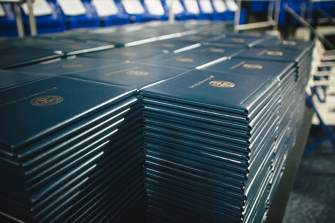 Stacks of MTSU degree covers await new graduates in this commencement ceremony file photo inside Murphy Center. Spring 2021 graduates will return to Murphy Center May 7-9 for the first time since 2019 for a three-day, 10-event, socially distanced commencement weekend. Click on the photo to search an alphabetical list of all the participating graduates' ceremony dates and times. (MTSU file photo by GradImages)