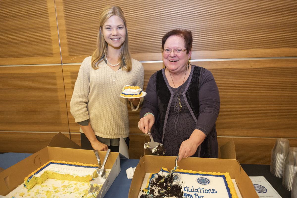Ella Morin, left, an MTSU Honors College student from Knoxville, Tenn., volunteers with Honors College executive aide Cindy Phiffer in serving cake at the Phi Kappa Phi initiation event in November 2019. Morin is a member of Omicron Delta Kappa. (MTSU photo by Cat Curtis Murphy)