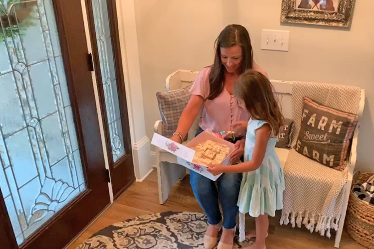 Brittany Marks, left, an MTSU alumna and adjunct professor of nursing, and her daughter, Camryll, check out some Rice Krispies treats from Country Music Television and Kellogg’s. Marks was featured June 3 on “CMT Celebrates Our Heroes,” a tribute to people fighting COVID-19. (Screen capture)