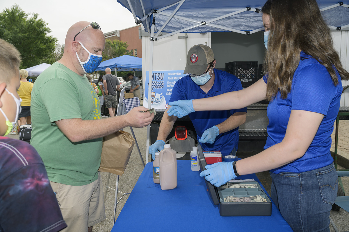 MTSU National Alumni Association Board member Jonathan Harmon of Murfreesboro buys the popular chocolate and whole white milk at the MTSU Creamery vendor spot Saturday, June 6, at the Main Street Murfreesboro Saturday Market outside the Rutherford County Courthouse. (MTSU photo by Andy Heidt)