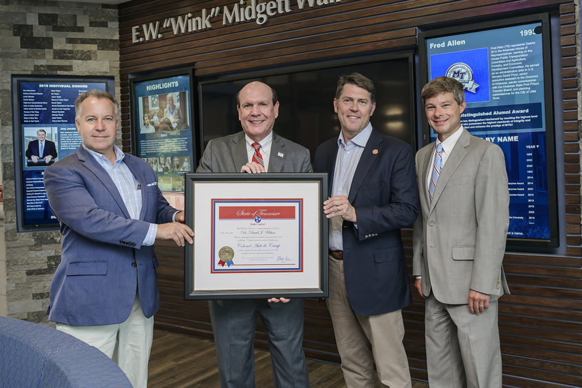 David Urban, second from left, dean of the Jennings A. Jones College of Business MTSU, received this framed certificate after he was commissioned as a "Colonel, Aide-de-Camp," which is the highest honor granted by the governor of Tennessee. It is conferred for extraordinary service to the state. Pictured inside the Business and Aerospace Building are, from left, state Rep. Mike Sparks, who nominated Urban; Urban; state Sen. Shane Reeves; and state Rep. Charlie Baum, who’s also an MTSU economics professor. (MTSU photo by Andy Heidt)