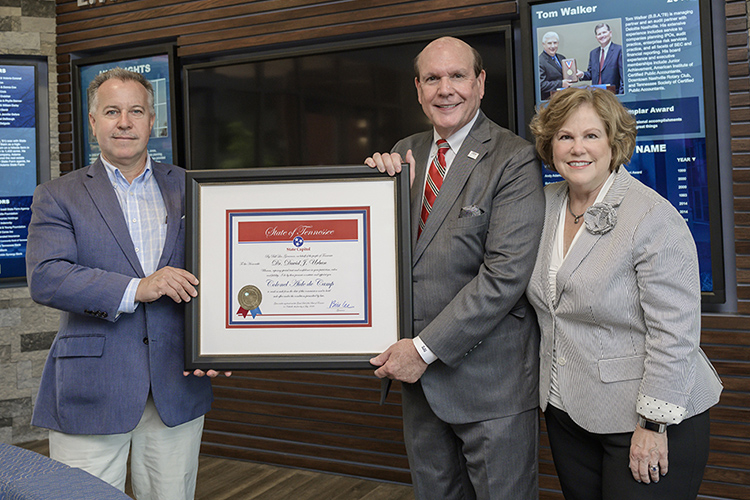 David Urban, second from right, dean of the Jennings A. Jones College of Business MTSU, is shown with a framed certificate he was presented after recently being commissioned as a "Colonel, Aide-de-Camp," which is the highest honor granted by the governor of Tennessee. It is conferred for extraordinary service to the state. Pictured inside the Business and Aerospace Building are, state Rep. Mike Sparks, left, who nominated Urban; and Urban’s wife, Gina, right. (MTSU photo by Andy Heidt)