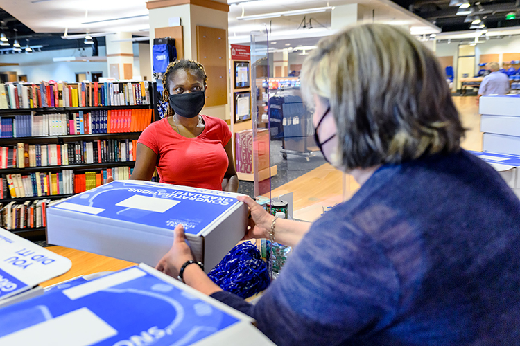 MTSU August graduate Mayowa Adeniyi, left, listens to Associate Registrar Cindy Johnson as they discuss Adeniyi's "True Blue Graduation Box" and commencement cap and gown Friday, July 31, on the first day students could pick up their graduation regalia in the Student Union. MTSU will present almost 800 summer 2020 graduates with degrees during a virtual commencement, set Saturday, Aug. 8, to celebrate their accomplishments. (MTSU photo by J. Intintoli)