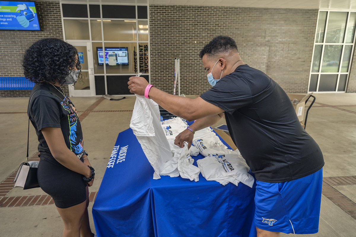 MTSU senior Tamia Hambrick, left, of Antioch, Tenn., a 2020 Scholars Academy peer mentor, receives a T-shirt for her program participation from staff member Marvin Spencer, during a recent gift giveaway for freshmen and mentors outside of the Office of Student Success in Peck Hall. (MTSU photo by Andy Heidt)